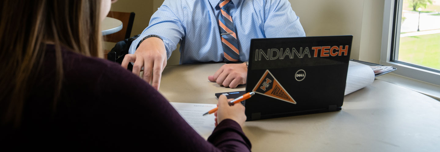 Admissions representative walking someone through a quick facts sheet